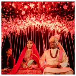 Brightly decorated outdoor event entrance with flowers and drapes